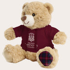 Beige teddy bear wearing a maroon shirt with a logo and text on a white background