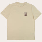 A cream-colored short-sleeve crewneck t-shirt with a small dark red crest graphic printed on the left chest, displayed flat against a white background.