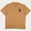 A tan short-sleeve polo shirt with a small dark brown embroidered crest on the left chest, displayed flat against a solid white background.